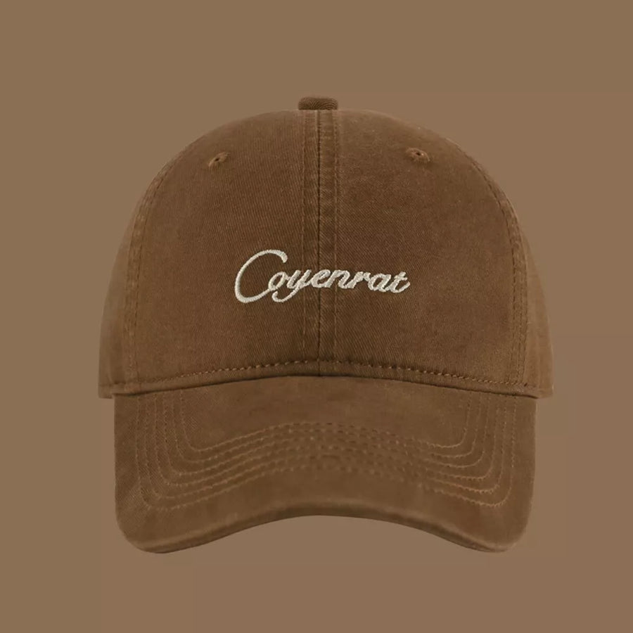 Brown baseball cap with white embroidered text and stitched brim detail.