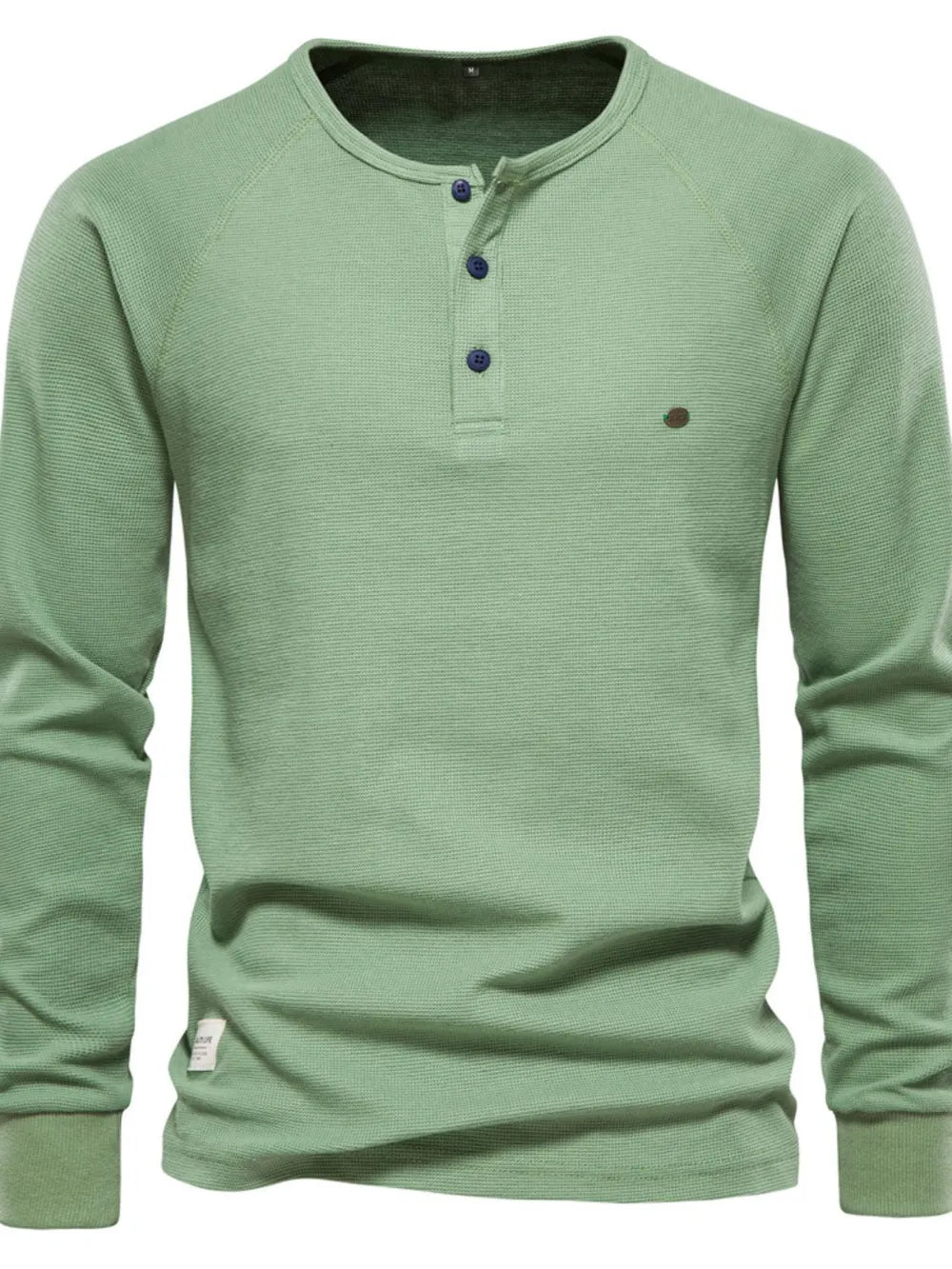 Matcha green waffle knit henley top with raglan sleeves and button placket.