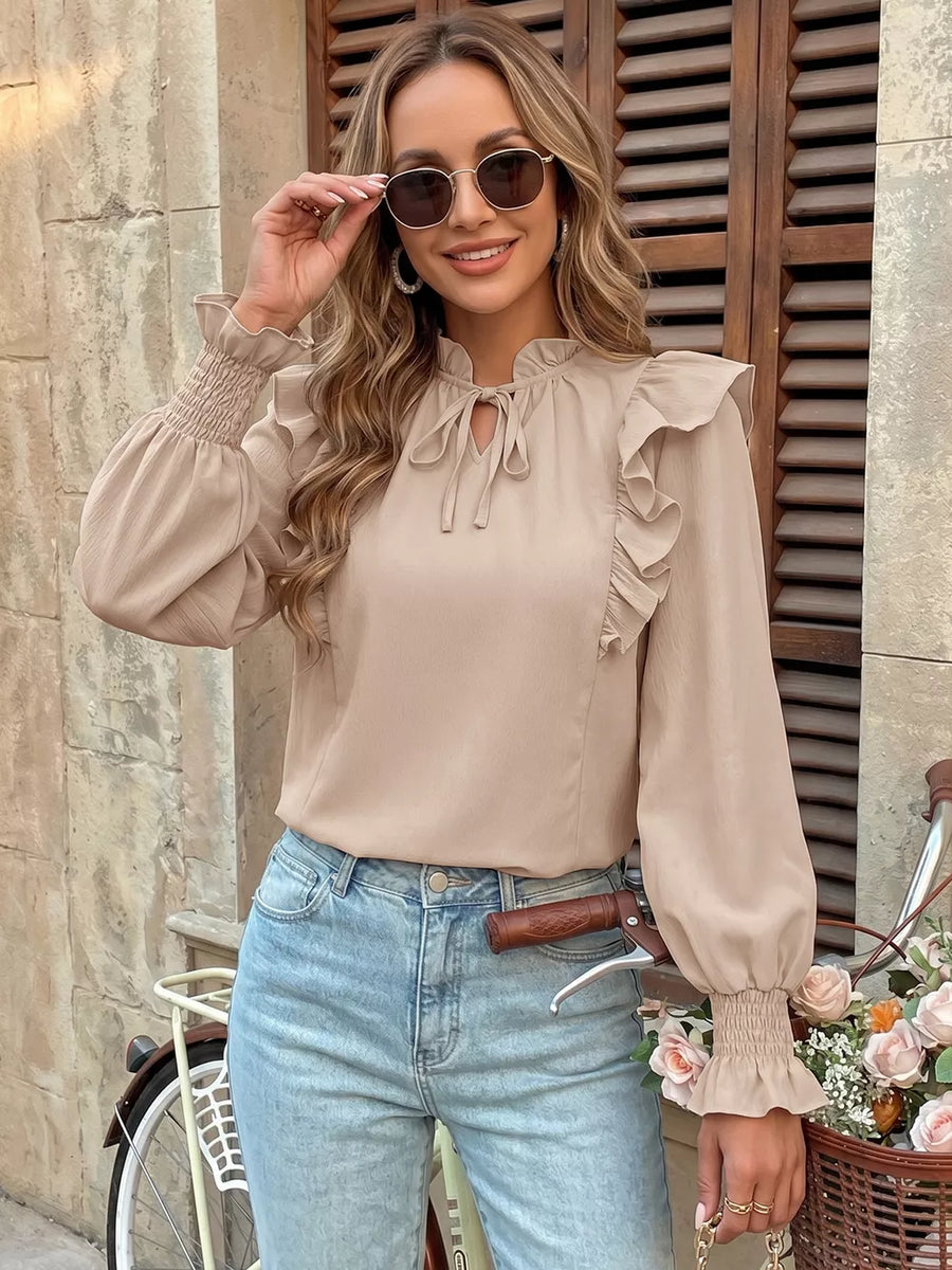 Beige long sleeve shirt with ruffled neckline and cuffs, tie detail