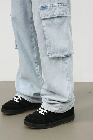 Oversized light wash denim cargo pants with large side pockets.