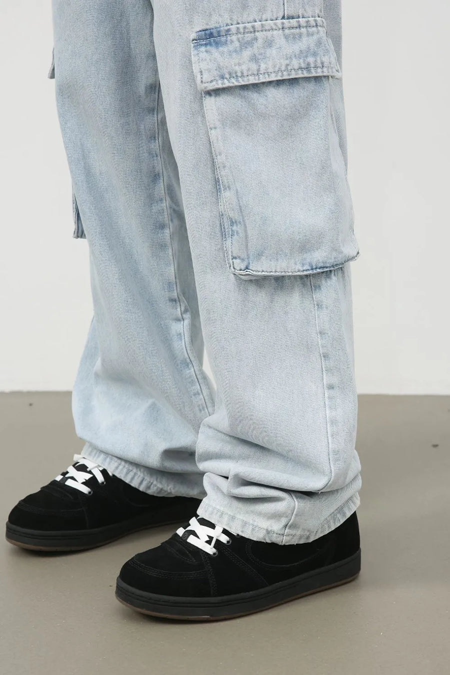 Oversized light wash denim cargo pants with large side pockets.