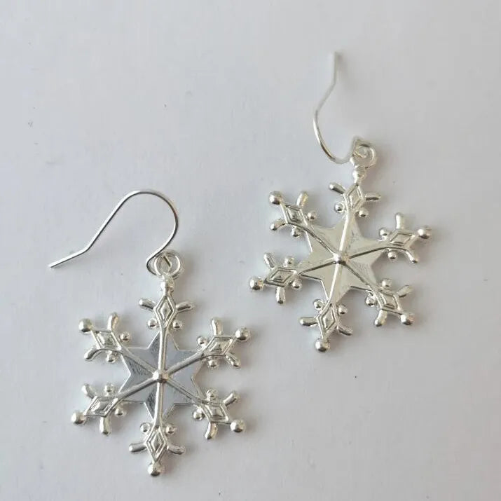 Silver snowflake drop earrings with intricate detail and hooks.