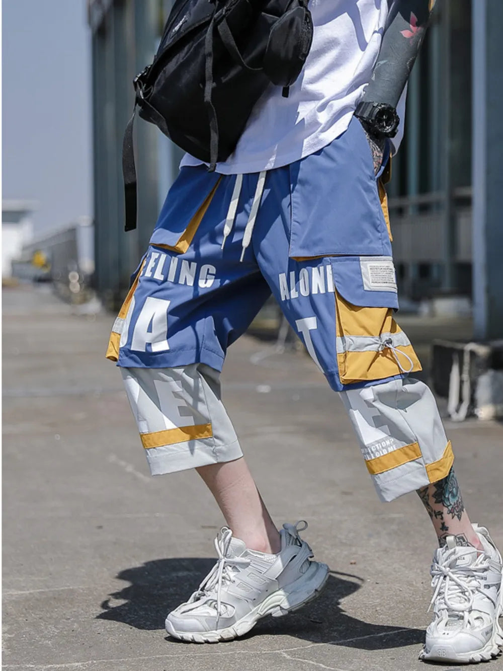 Color block utility cargo pants in light blue with yellow accents and graphic text detail.