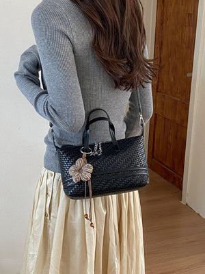 Black crossbody bag featuring woven texture and woven