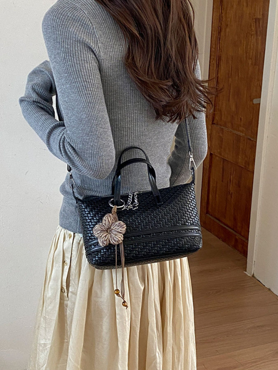 Black crossbody bag featuring woven texture and woven