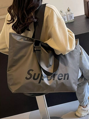 Spacious grey Oxford cloth travel shoulder bag with black "Superen" graphic and strap.