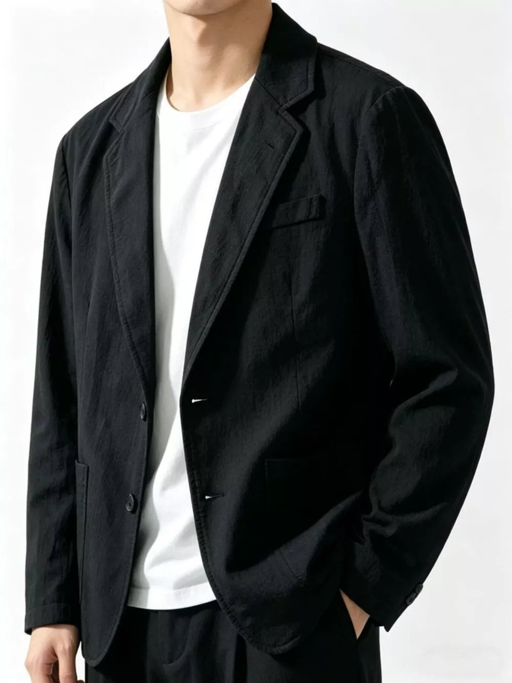 Black long sleeve blazer with notched lapels and two-button closure, styled with a white t-shirt.