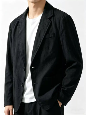 Black long sleeve blazer with notched lapels and two-button closure, styled with a white t-shirt.