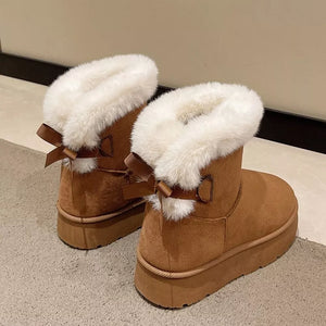 Caramel suede round-toe boots with white faux fur trim and bow details.