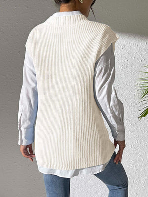 Ivory ribbed knit sleeveless vest over a light blue collared shirt.