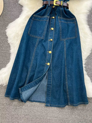 Light blue denim dress with belt, button front, chest pockets, and slit skirt.