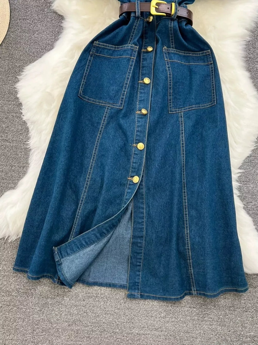 Light blue denim dress with belt, button front, chest pockets, and slit skirt.