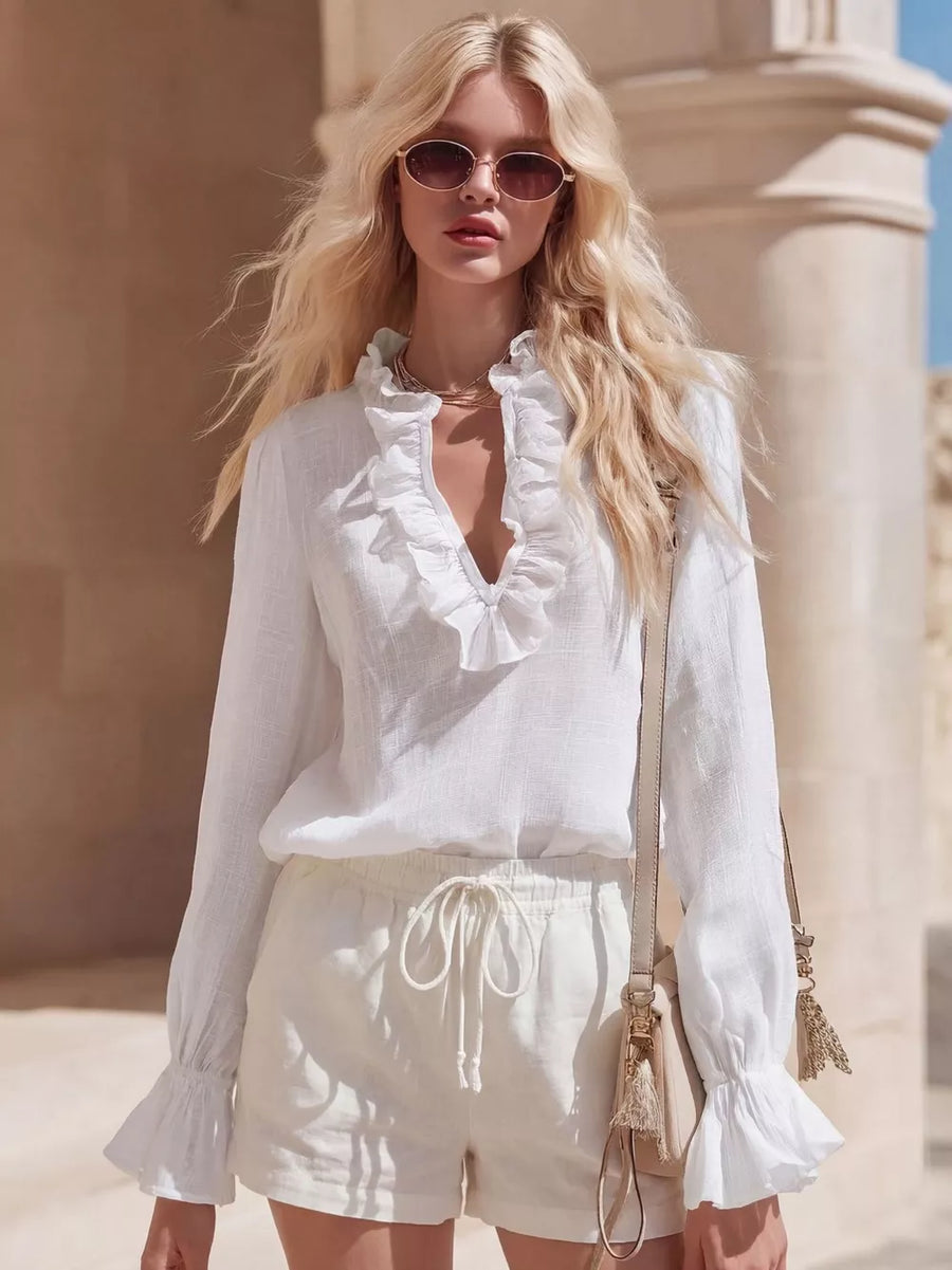 White maternity shirt with V-neck ruffles and flared cuffs.
