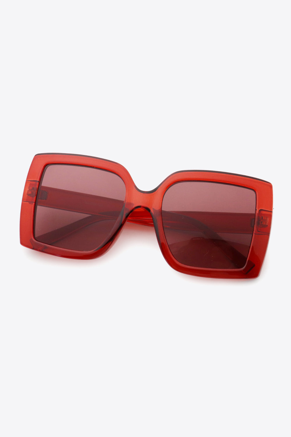 Crimson acetate rectangular sunglasses with bold frames and dark lenses.