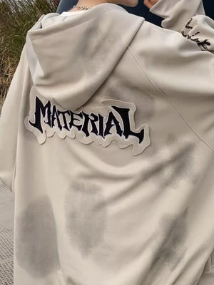 Oversized apricot zip-up hoodie with "MATERIAL" graphic patch on back.