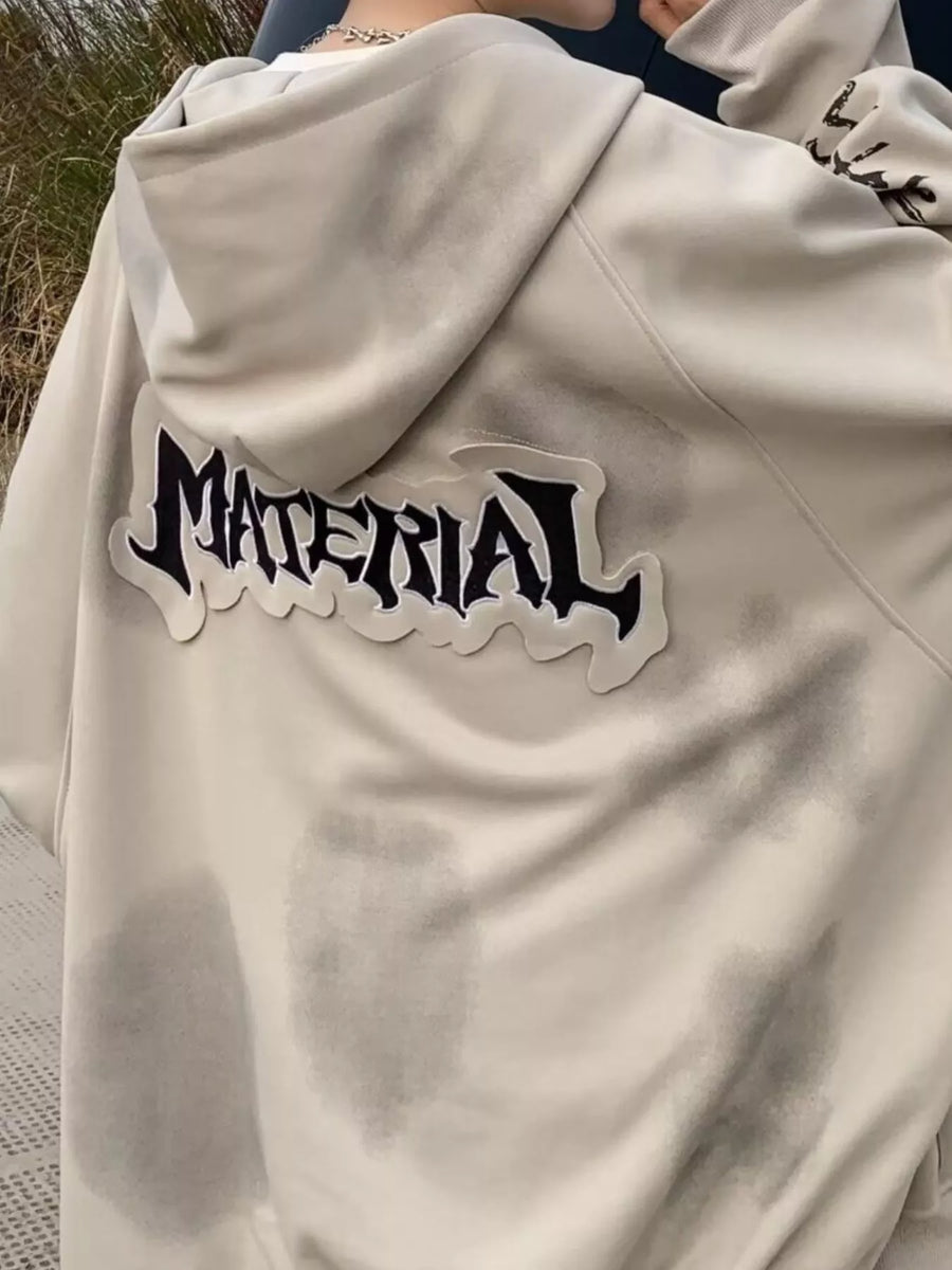 Oversized apricot zip-up hoodie with "MATERIAL" graphic patch on back.