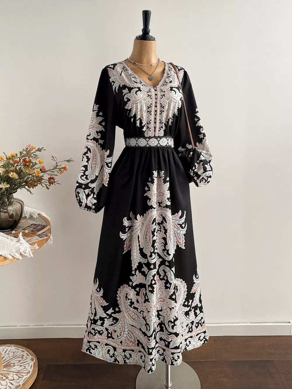 Black maxi dress with V-neck, balloon sleeves, and paisley print.