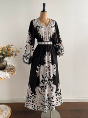 Black maxi dress with V-neck, balloon sleeves, and paisley print.