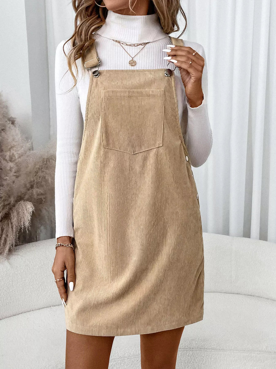Tan corduroy overall dress with front pocket and button details.