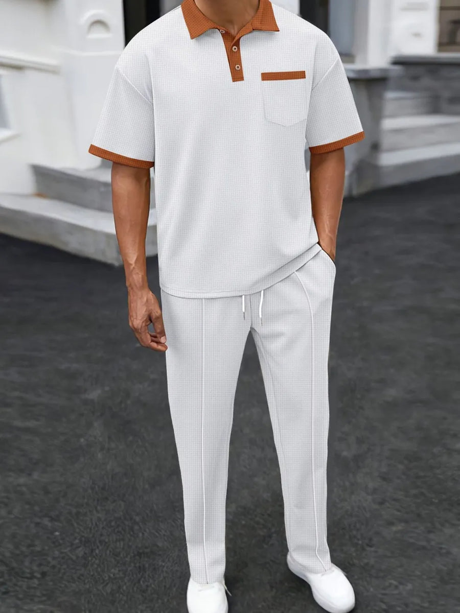 White textured polo shirt with contrast collar and pocket, paired with matching track pants.