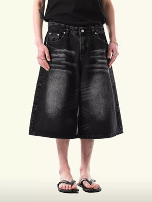 Black denim capris with relaxed fit and distressed details.