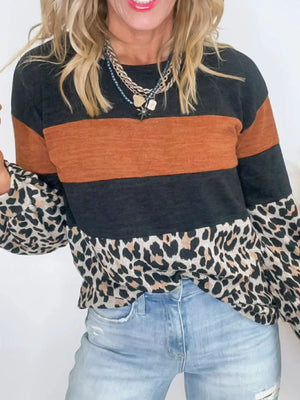 Leopard print patchwork blouse with orange and black stripes, long sleeves, and crew neck.