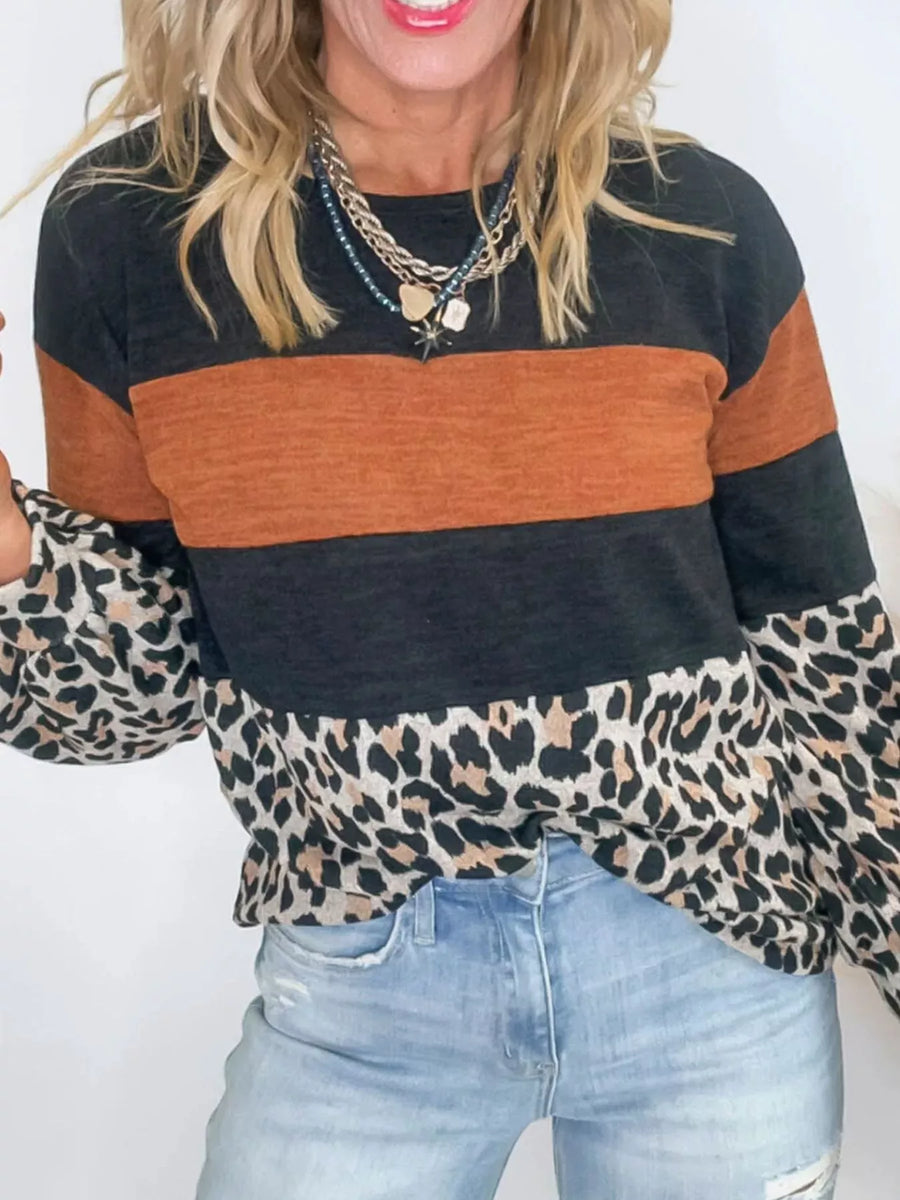 Leopard print patchwork blouse with orange and black stripes, long sleeves, and crew neck.