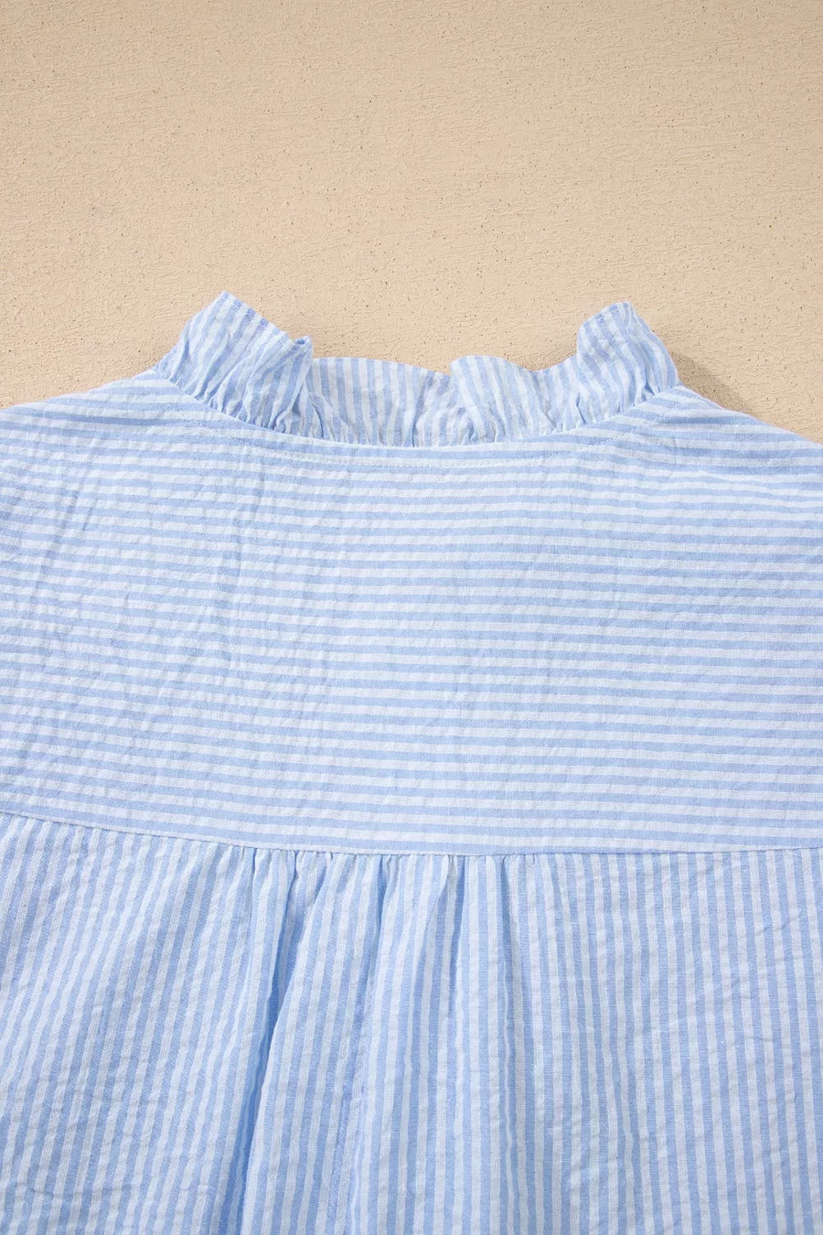 Blue and white striped cotton shirt with ruffle neckline and gathered waist.