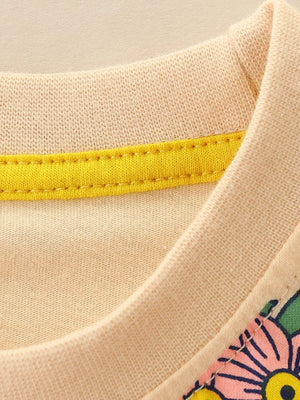 Toddler crew neck t-shirt in tan cotton with yellow trim and floral graphic detail.