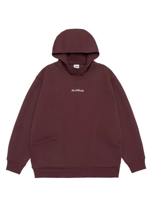 Dark Red oversized hoodie with "Be Difficult." graphic and front pockets.