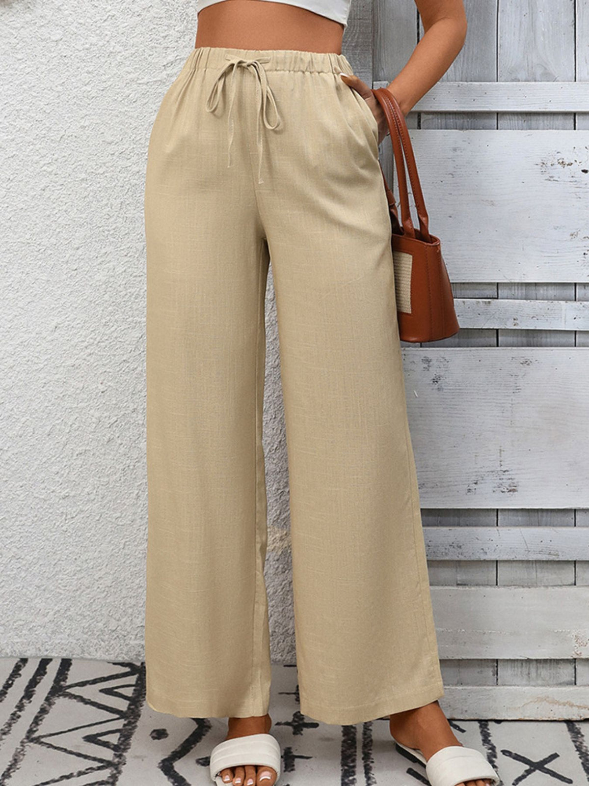 Apricot high-waist wide-leg pants with drawstring and pockets.