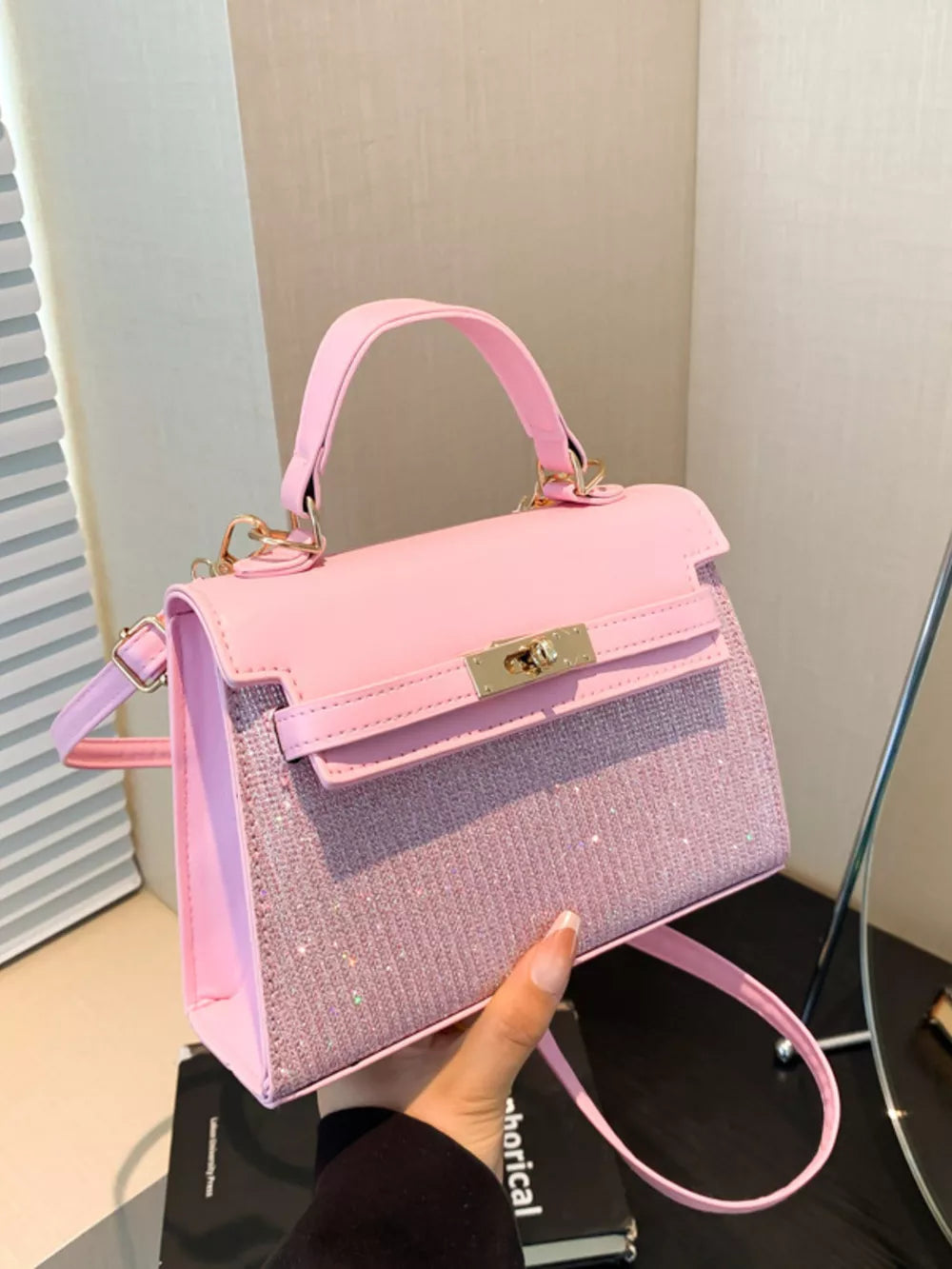 Pink glitter textured mini crossbody bag with gold hardware and top handle.