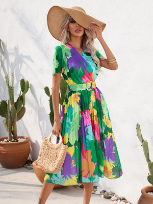Tropical pleated midi dress with belt in vibrant floral print and green.