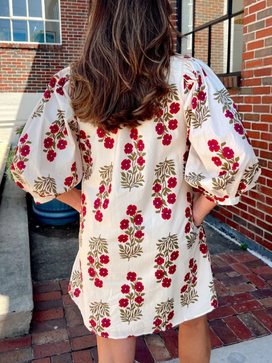 V-neck mini dress with pockets in cream cotton with red floral print and puff sleeves.