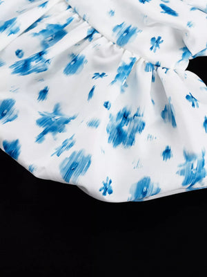 White dress with blue abstract floral print and ruffled hem
