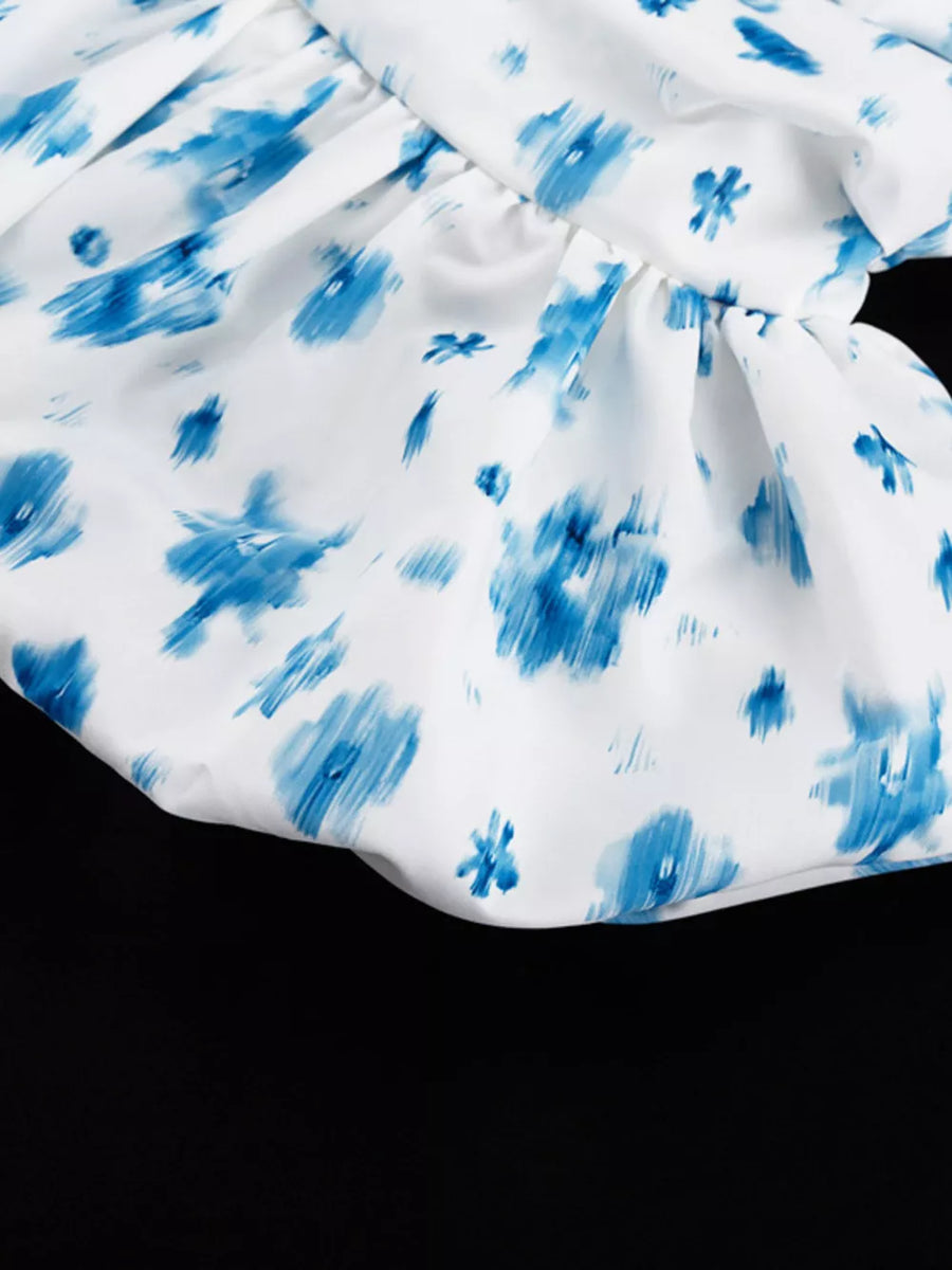 White dress with blue abstract floral print and ruffled hem