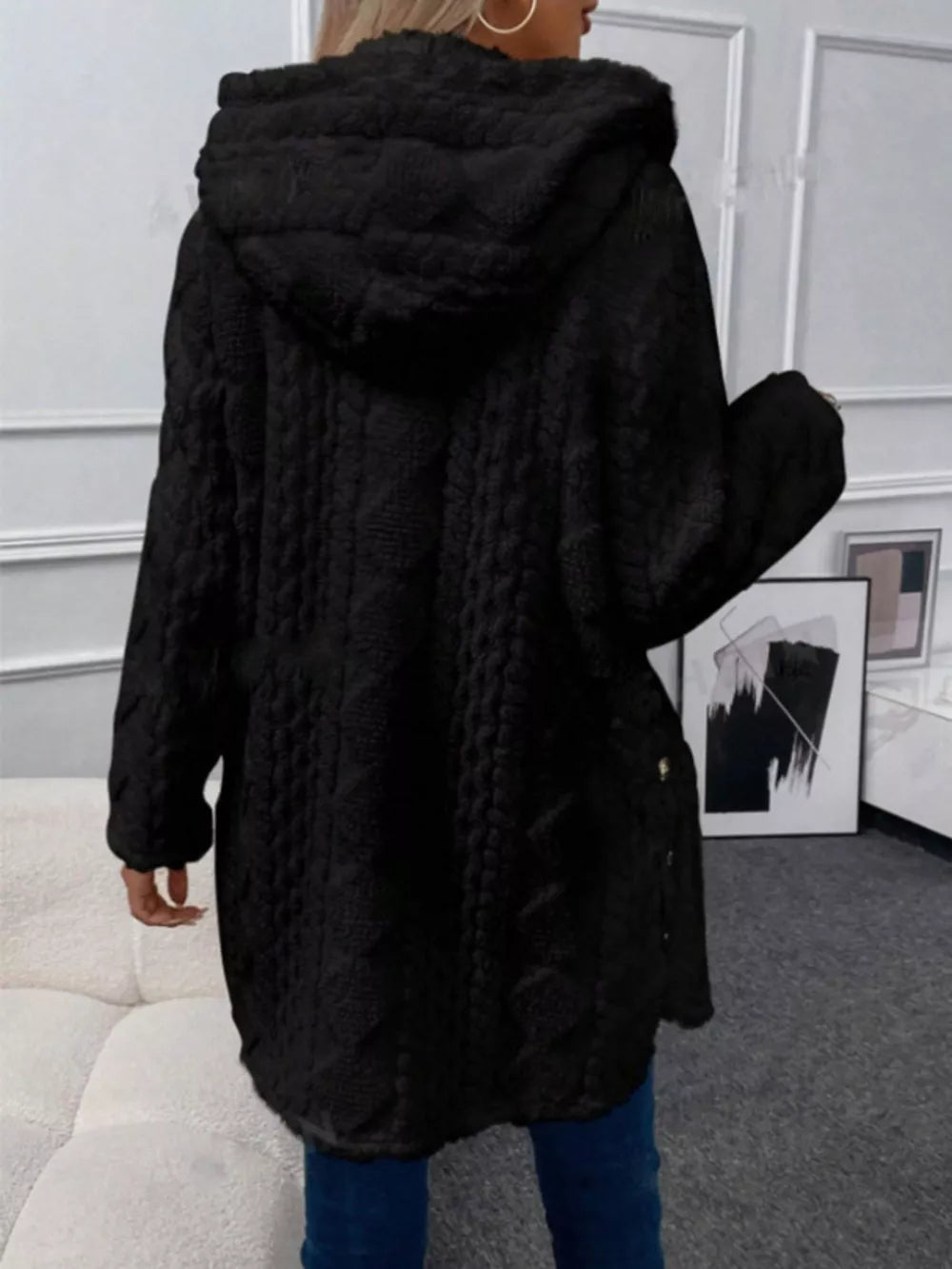 Black hooded fleece trench coat with cable knit texture and button detail.