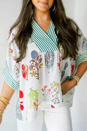 White floral print shirt with green striped contrast trim and V-neck.