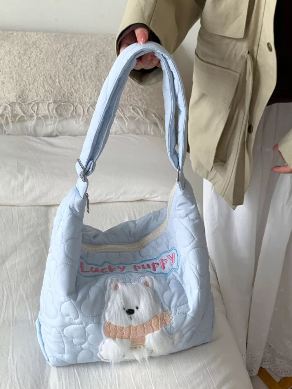 Light blue quilted crossbody bag with white bear applique and "Lucky Puppy" embroidery.