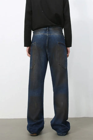 Faded panel wide-leg denim trousers in medium wash with distressed details.
