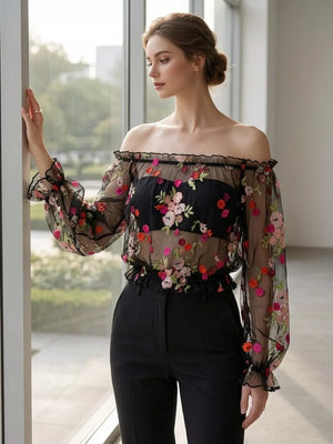 Black off-shoulder sheer t-shirt with embroidered floral detail and ruffled trim