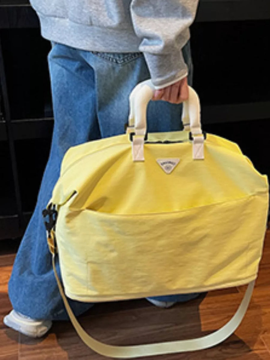 Yellow Oxford cloth duffel bag with white handles and a crossbody strap.