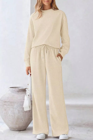 Apricot loungewear set with textured fabric, crew neck sweatshirt, and drawstring wide-leg pants.