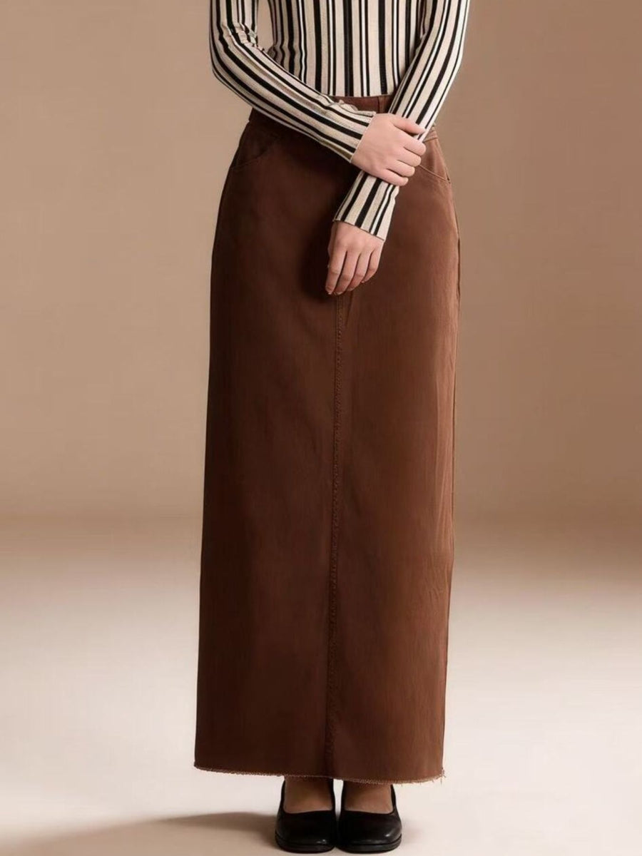 Brown cotton maxi denim skirt with raw hem and front seam detail.