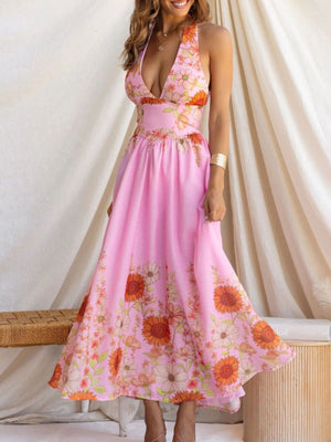 Pink floral halter neck maxi dress with plunging neckline and flowing skirt.
