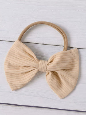 Baby headband with large beige ribbed bow and thin elastic band