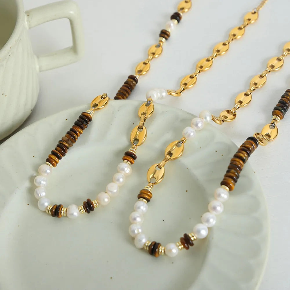 Gold pearl and tiger eye statement necklace with oval chain links.