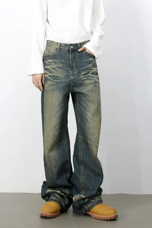 Distressed denim wide-leg trousers in medium wash with faded details and a relaxed fit.