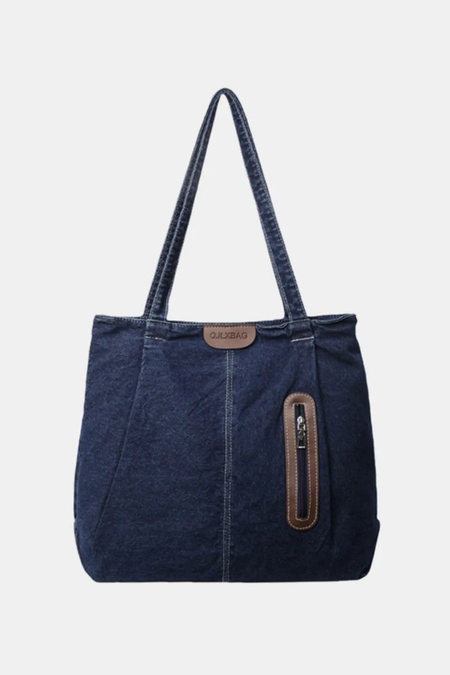 Denim tote bag in dark blue with leather trim and zippered pocket detail.