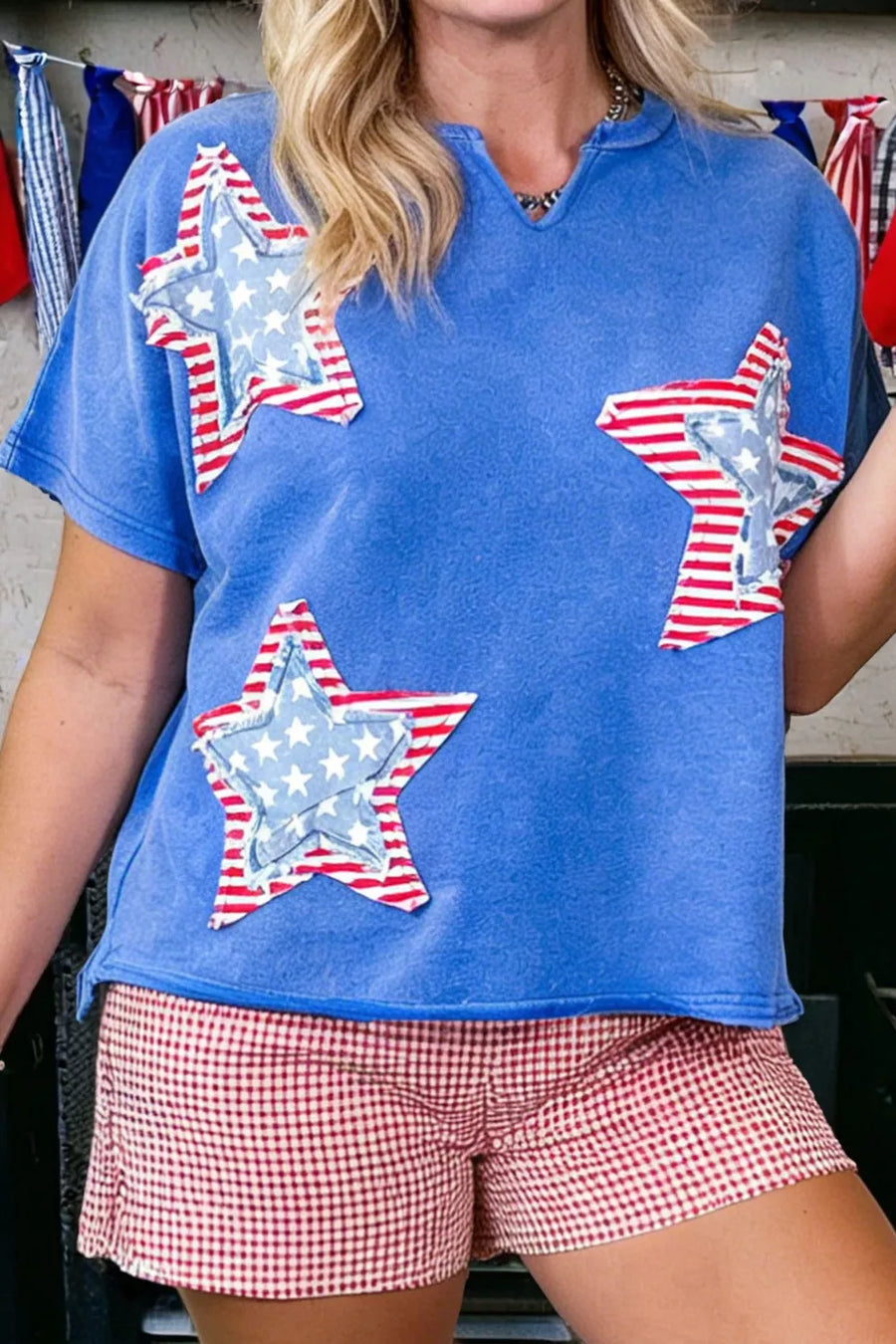 Blue cotton t-shirt with notched neck and patriotic star appliqués.